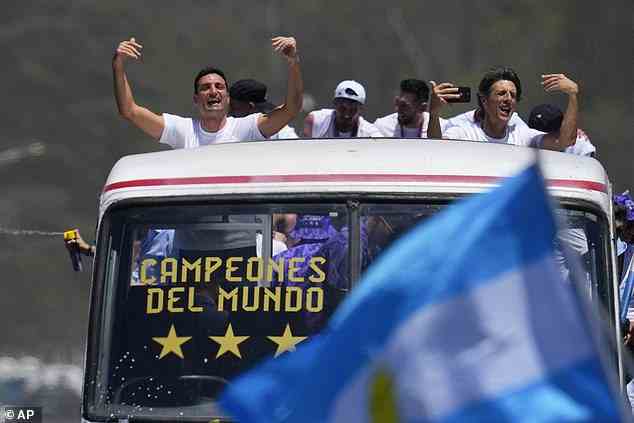 The team's coach Lionel Scaloni (left) celebrates with supporters as the bus drives through the parade