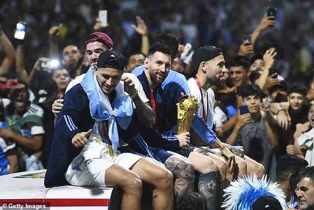 Captain Messi holds the World Cup trophy on the bus after the team landed back in Argentina