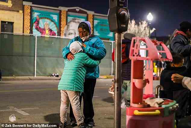 A mom consoles her child after making it across the border late Tuesday ahead of the 12am Wednesday deadline, which has been extended by a week as the Supreme Court mulls whether it will keep the COVID-era guidance in place
