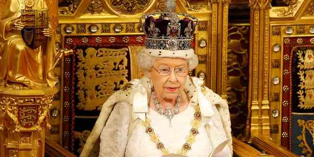 Queen Elizabeth II sitzt auf einem goldenen Thron.