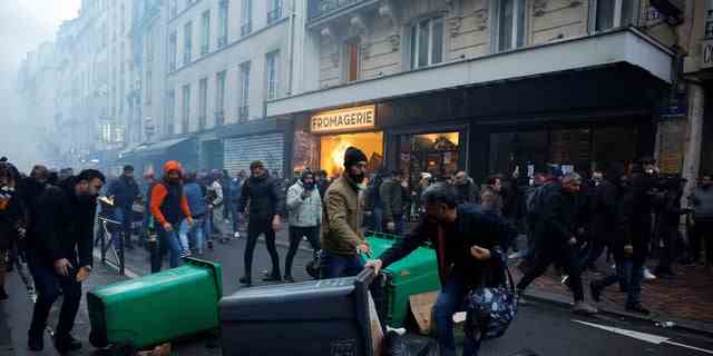 Demonstranten stoßen während einer Demonstration in der Nähe der Rue d'Enghien mit der französischen Polizei zusammen, nachdem am 23. Dezember 2022 in einem zentralen Viertel von Paris Schüsse abgefeuert wurden, bei denen mehrere Menschen getötet und verletzt wurden.  