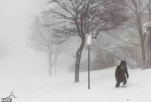 A person navigates deep snow during the winter storm affecting large portions of the United States, in Buffalo