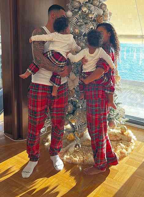 Family affair: The Little Mix singer and her beau donned matching red checked PJs, with their young children sporting the nightwear set too as they gathered around a Christmas tree