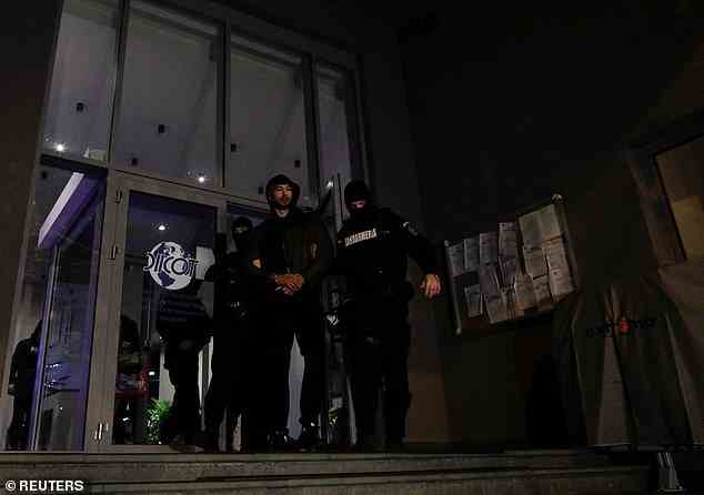 Tate is escorted by police officers outside the headquarters of the Directorate for Investigating Organised Crime and Terrorism in Bucharest
