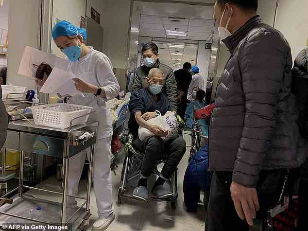 Im Bild: Ein Covid-Patient, der am 28. Dezember im Tianjin First Center Hospital in Tianjin im Nordosten Chinas in einen Rollstuhl gefahren wird