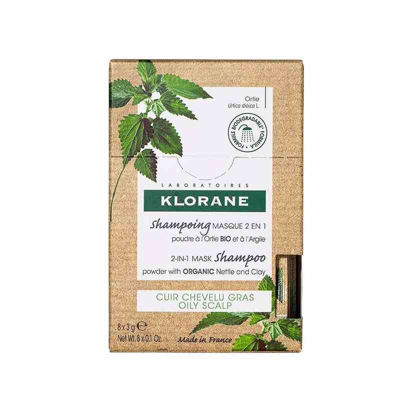 Klorane 2-in-1-Masken-Shampoo-Pulver mit Bio-Brennnessel und Tonerde brauner Karton mit Blattdesign auf weißem Hintergrund