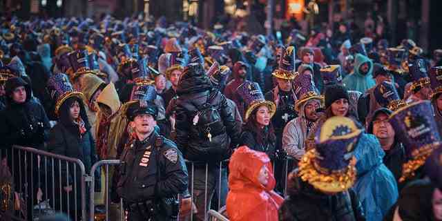 Nachtschwärmer versammeln sich während der Silvesterfeier am Times Square am Samstag, den 31. Dezember 2022, in New York unter dem Regen.