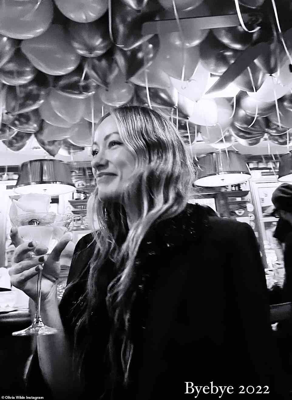 A final farewell: Olivia Wilde shared a black and white photo of herself in a room filled with balloons and added the caption, 'Byebye 2022'
