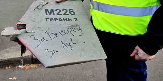 Ein Polizeiexperte hält ein Fragment einer Drohne mit einer handschriftlichen Inschrift "Für Belgorod.  Für Luch" nach einem Drohnenangriff in Kiew am 17. Oktober 2022 inmitten der russischen Invasion in der Ukraine. 