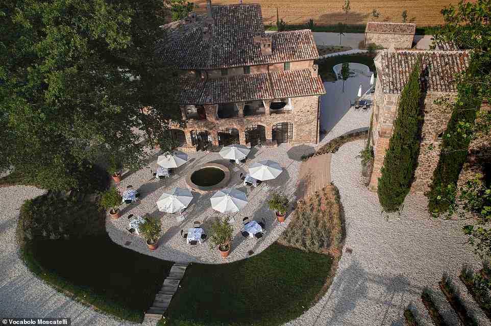 Vocabolo Moscatelli, pictured, is a re-imagined 12th-century monastery in the Umbrian countryside with a 'piazza-style square with umbrella-topped tables and a bubbling fountain'