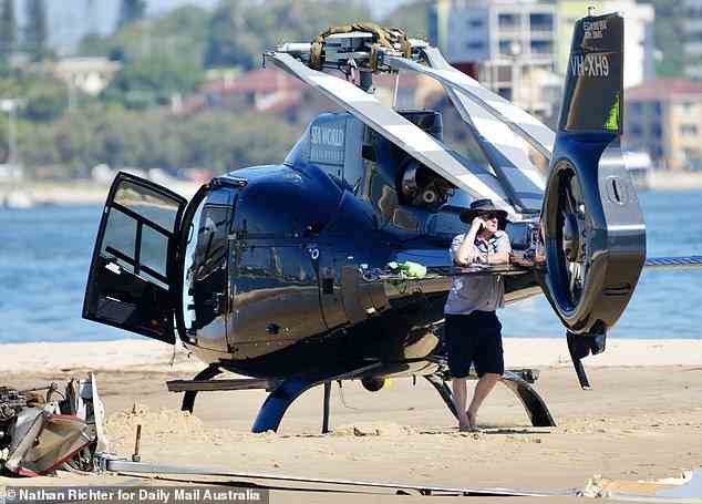 A man is seen on the phone by a Sea World chopper as emergency services and officers from the Australian Transport Safety Bureau investigated the circumstances of the crash