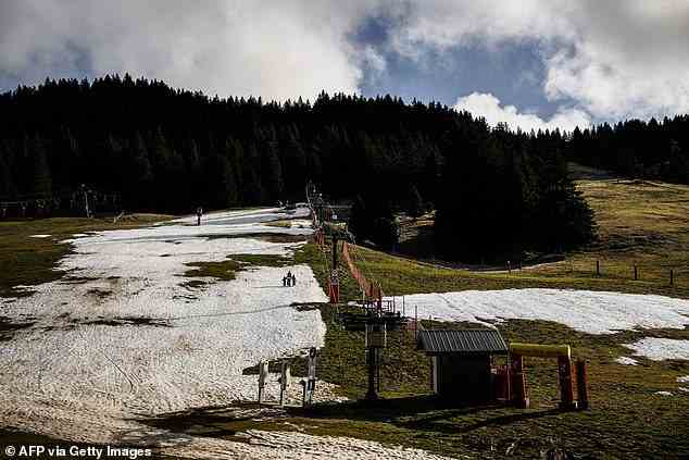 Hikers walk past a stopped chairlift at Le Semnoz ski resort, near Annecy, last week