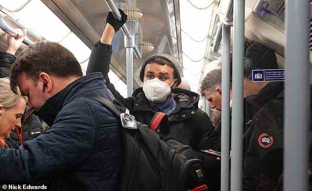 Commuters on the London Underground during rush hour this morning wore masks amid warnings from experts to 'ratchet up precautions'