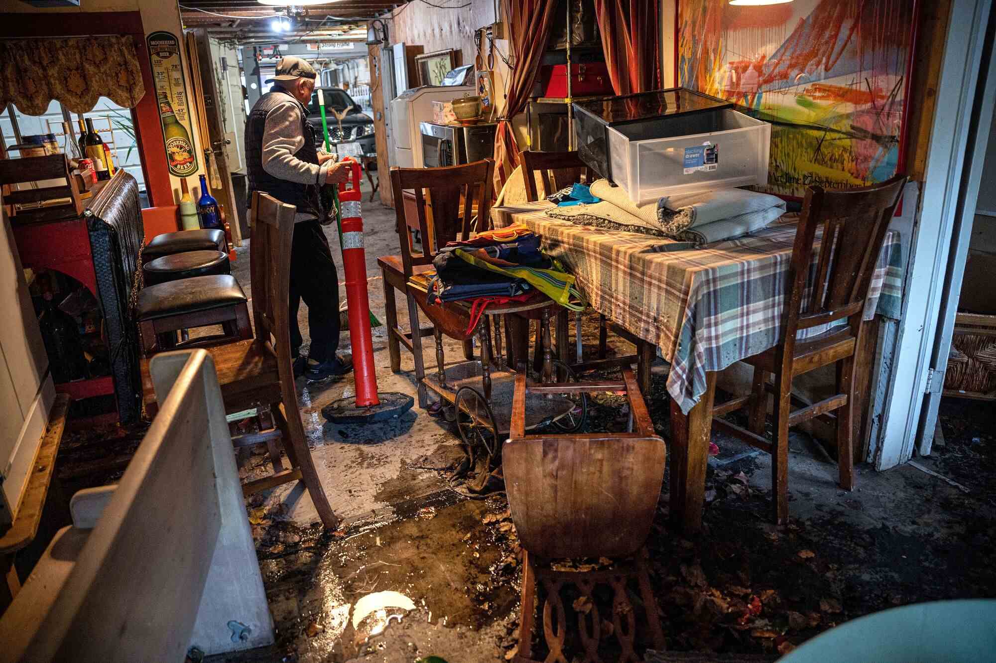 Ein Mann bewegt Möbel, während Hochwasser in ein Haus in San Francisco eindringt.