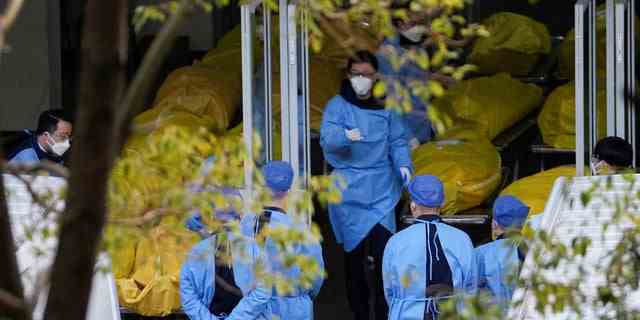 Ein Mitarbeiter geht neben mehreren Leichensäcken in einem Bestattungsunternehmen spazieren, während die COVID-19-Ausbrüche in Shanghai, China, am 4. Januar 2023 andauern.