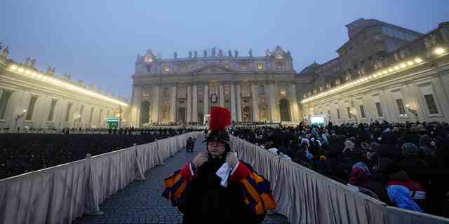Eine Wache steht, während der Nebel die Kuppel des Petersdoms auf dem Petersplatz im Vatikan bedeckt, vor der Trauermesse für den verstorbenen emeritierten Papst Benedikt XVI., Donnerstag, 5. Januar 2023. 