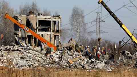 Arbeiter sind am 3. Januar 2023 abgebildet, wie sie Trümmer am Ort des tödlichen Angriffs in der Ostukraine sammeln.