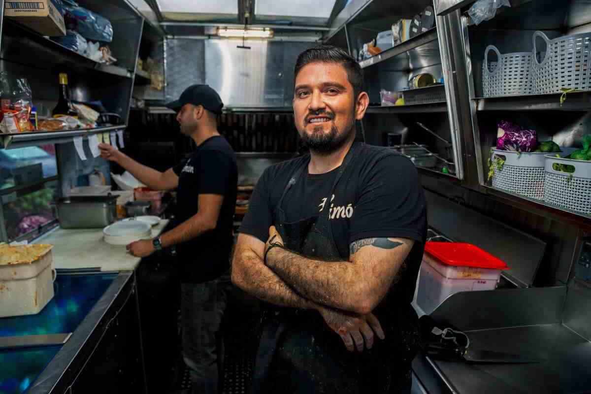 Ein lächelnder Mann mit verschränkten Armen in einer Food-Truck-Küche
