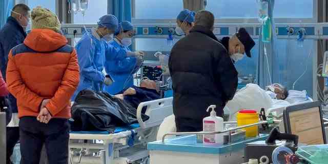 Medizinisches Personal untersucht einen älteren Patienten, als er am Samstag, den 7. Januar 2023, in einer Notaufnahme eines Krankenhauses in Peking ankommt. 