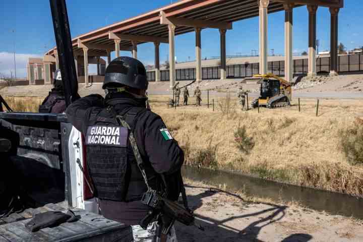 Ein Soldat der mexikanischen Nationalgarde steht Wache auf der Südseite der Grenze, während Truppen der texanischen Nationalgarde am Samstag Posten aufstellen, um einen zweiten Zaun an der Grenze zwischen den USA und Mexiko zu verlängern.