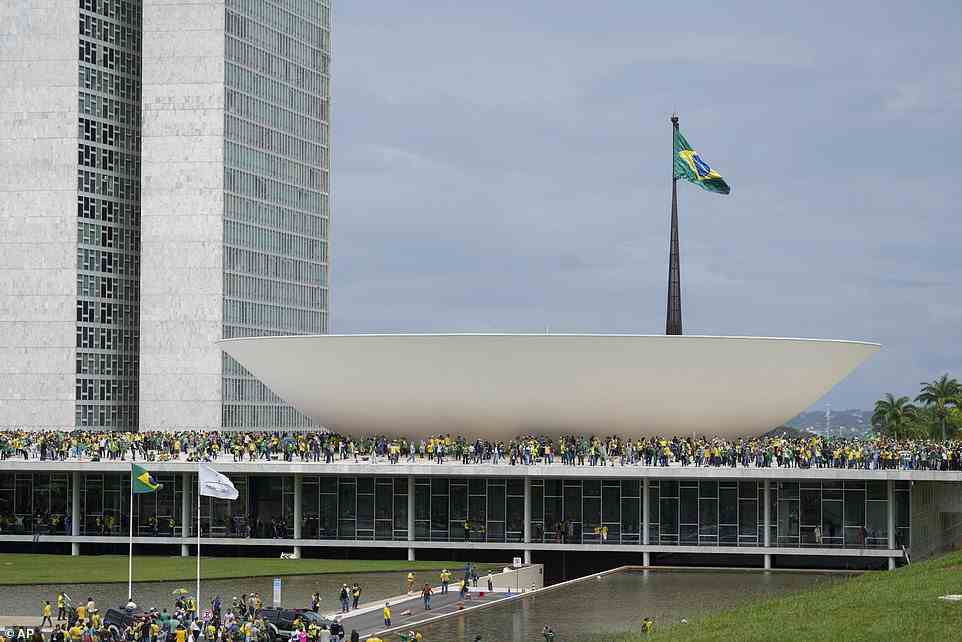 Unterstützer von Bolsonaro sind zu sehen, wie sie am Sonntag die Barrieren durchbrechen und das Gebäude betreten