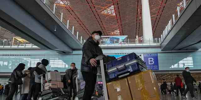 Passagiere aus Hongkong kommen am Sonntag, 8. Januar 2023, in der internationalen Ankunftshalle des Terminals 3 des Beijing Capital International Airport in Peking an. 