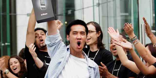 Umringt von jubelnden Mitarbeitern des Apple Store verlässt einer der ersten iPhone-Käufer am 29. Juni 2007 den Store auf der Fifth Avenue in Manhattan. 