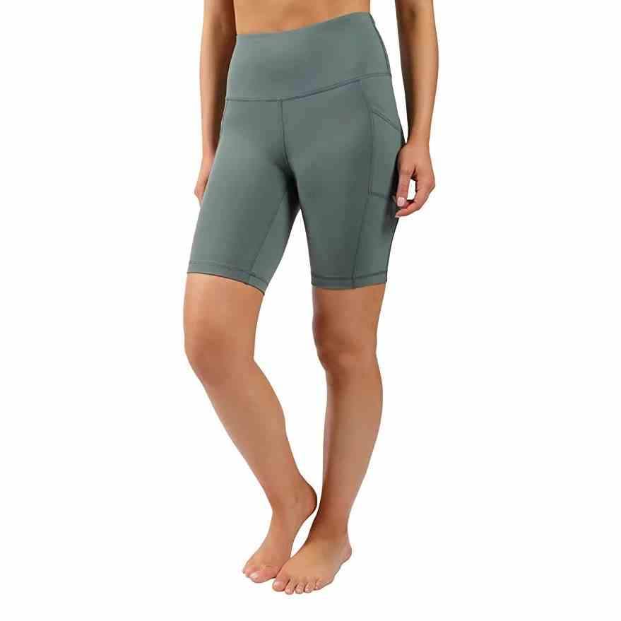 90 Degree By Reflex Power Flex Biker Shorts mit hoher Taille Aufnahme des Modells von der Taille abwärts in blassblau-grünen Biker-Shorts auf weißem Hintergrund