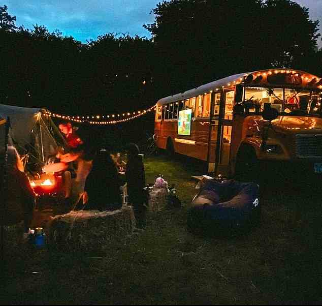 Der Bus sieht mit Lichterketten während einer abendlichen Gartenparty vor dem Haus niedlich und gemütlich aus