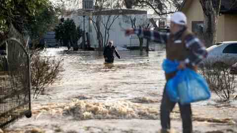 Die Bewohner versuchen am Mittwoch, ihre Habseligkeiten einzusammeln, bevor das Hochwasser in Merced, Kalifornien, ansteigt.