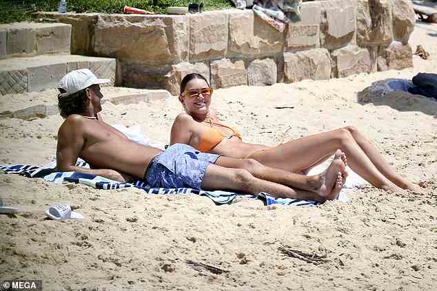 Phoebe streckte ihren Körper auf einem Strandtuch aus, während sie die Sommersonne aufsaugte und mit ihrer Freundin plauderte