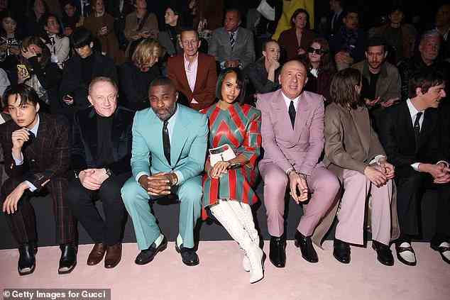 Front-row: Sabrina paired her stand-out boots with a small white leather Gucci handbag which featured gold hardware detailing (pictured alongside stars on the front row)