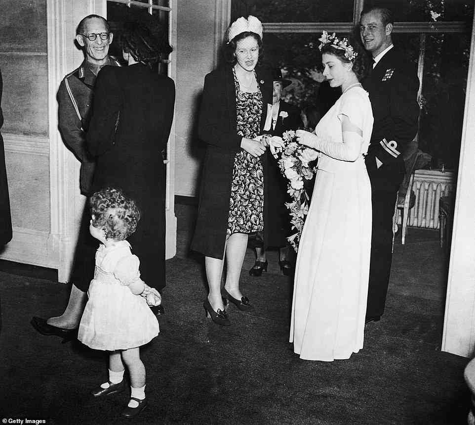 This photograph taken at the Elphinstone wedding in The Savoy caught Elizabeth standing beside a ¿handsome man in uniform¿ ¿ Prince Philip. ¿This was their first public appearance as a couple,¿ the hotel says