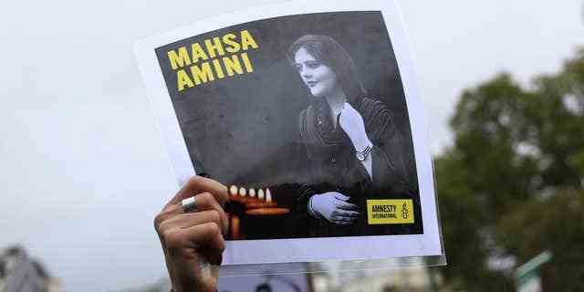 Ein Demonstrant zeigt ein Porträt von Mahsa Amini während einer Demonstration zur Unterstützung iranischer Demonstranten, die sich gegen ihre Führung wegen des Todes einer jungen Frau in Polizeigewahrsam am Sonntag, den 2. Oktober 2022 in Paris auflehnen. 