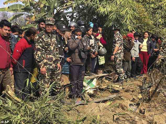 Einheimische beobachten das Wrack eines Passagierflugzeugs in Pokhara