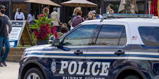 Diese Dateibilder zeigen, dass ein Polizeiauto draußen geparkt ist, während Menschen am 30. Oktober 2021 in Fairfax, Virginia, die Mosaic Shopping Center Mall besuchen. 