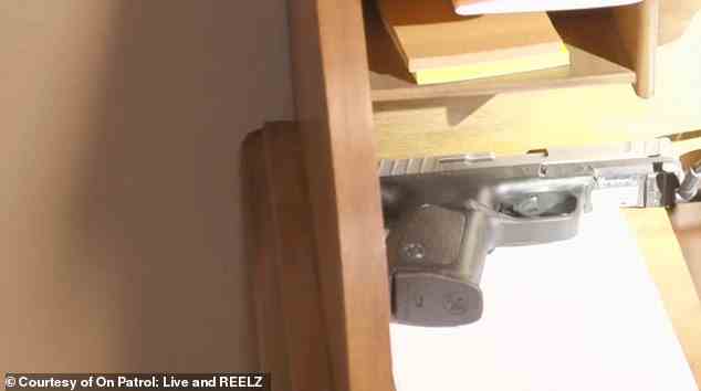 The handgun where it was discovered in the back of a desk in the apartment