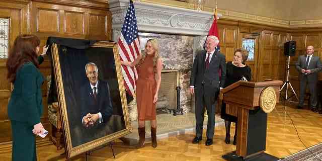 Arkansas Gov. Asa Hutchinson and first lady Susan Hutchinson look on as their granddaughter, Jaella Wengel, left, and daughter, Sarah Wengel, center, unveil the governor’s official portrait on Tuesday, Jan. 3, 2023, at the state Capitol in Little Rock, Ark. Hutchinson left office on Jan. 10 after serving eight years as governor. 