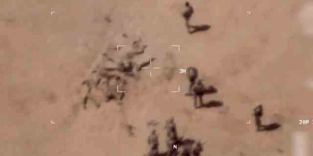 Dieses Bild aus einem Video zeigt Soldaten, die Leichen in der Nähe eines Armeestützpunkts im Norden Malis begraben.  Das französische Militär sagt, es habe Videos von russischen Söldnern, die Leichen in der Nähe eines Armeestützpunkts im Norden Malis begraben.