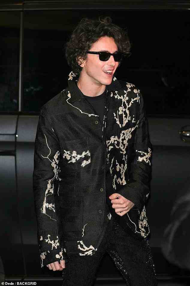 Edgy: Elsewhere, Timothee Chalamet cut a trendy figure in a black shirt embellished with silver patterns, which he styled with sparkling trousers and a T-shirt