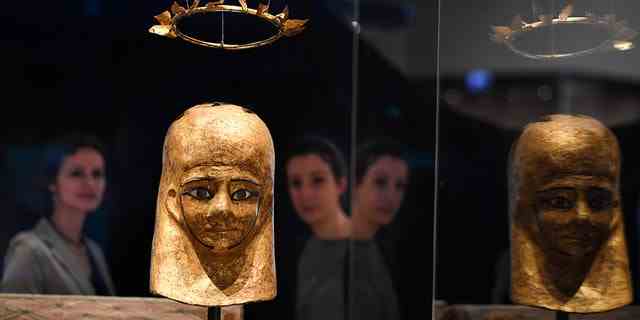 Museumsmitarbeiter sehen die Mumienmaske von Monstuef und den Kranz von Monstuef im National Museums Scotland in Edinburgh.