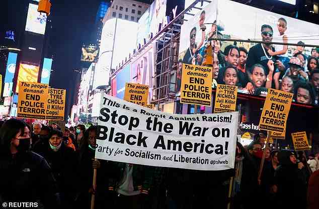 Left wing activists carry a banner during a protest on the day of the release in New York City's Times Square