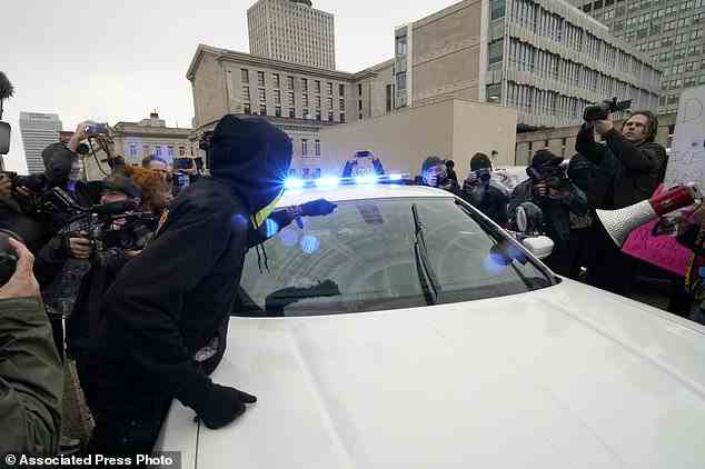 Protesters march in front of a police car on Saturday in Memphis
