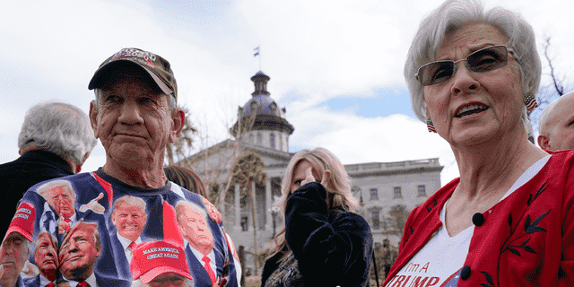 Bob Roach und seine Schwester Carolyn Church stehen vor dem South Carolina State House in Columbia, als sie am Samstag, den 28. Januar 2023, an einer Wahlkampfveranstaltung für den ehemaligen Präsidenten Donald Trump teilnehmen.