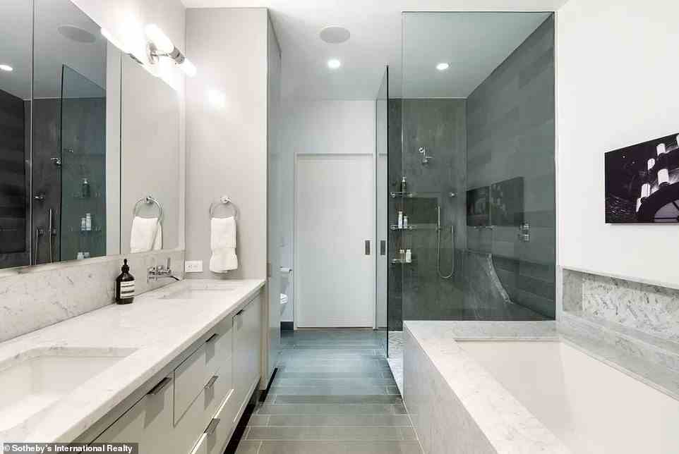 Es ist keine Überraschung, dass das Hauptbadezimmer mit einer Reihe großzügiger Annehmlichkeiten ausgestattet ist – wie einer tiefen Badewanne, einer separaten Dusche und einem Flachbildfernseher sowie durchgängig mit Carrera-Marmor und Blaustein-Oberflächen