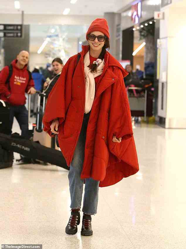 Sich von der Masse abheben: Anne Hathaway rockte ein leuchtend rotes Outfit, als sie sich darauf vorbereitete, den Flughafen von Salt Lake City zu verlassen, nachdem sie das Sundance Film Festival 2023 in Park City, Utah, besucht hatte