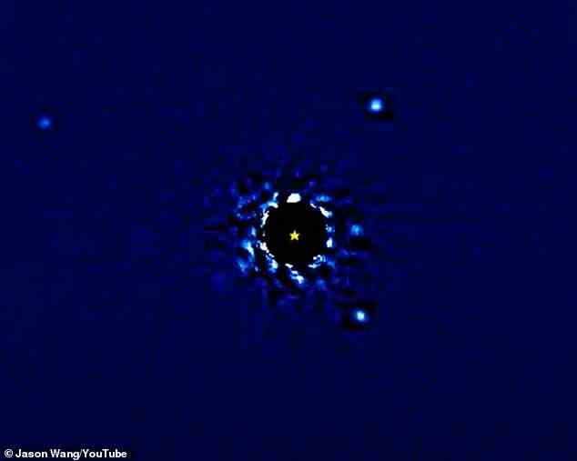 Es wurde mit Hilfe von 12-jährigen Beobachtungen zusammengestellt und zeigt die Exoplaneten als Lichtpunkte, die eine schwarze Scheibe umkreisen