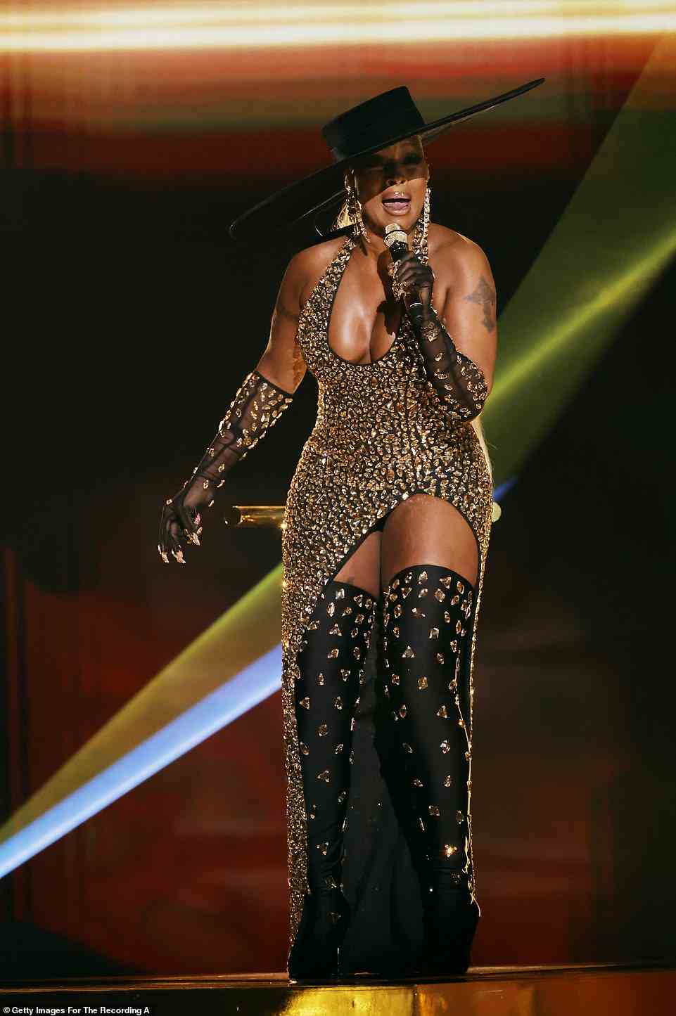 Sizzling: The Queen of R&B wore a plunging crystal-adorned form-fitting gown with a sizzling thigh-high slit and bedazzled black boots