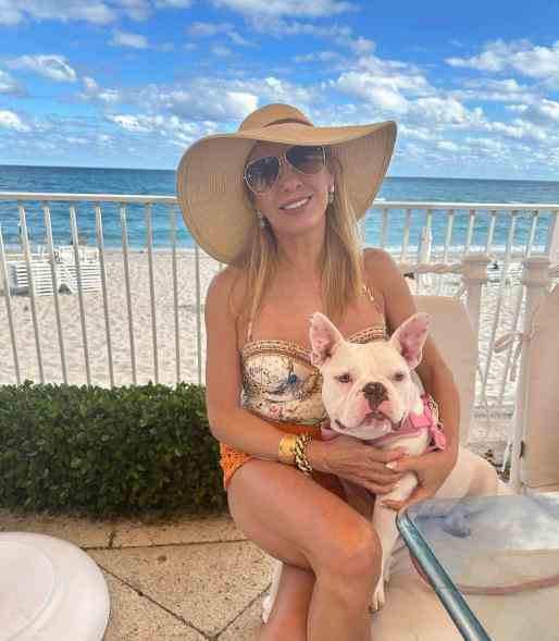 Ramona Singer hält einen Hund am Strand.