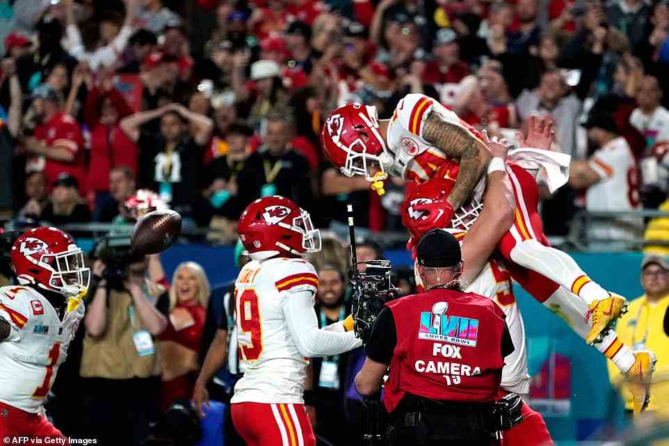 Kansas City Chiefs' offensive lineman Creed Humphrey lifts wide receiver Skyy Moore into the air after his touchdown